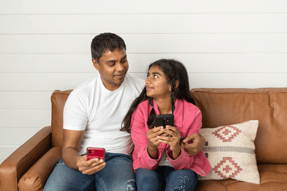 Father sitting with daughter looking at daughter