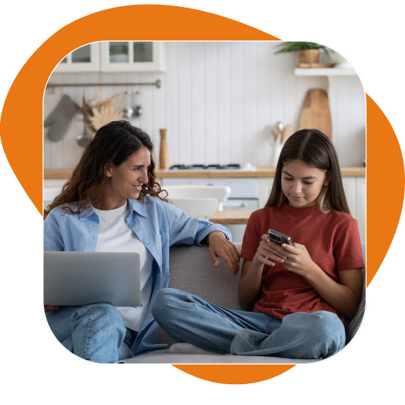 Mom wtih computer daughter with phone on couch