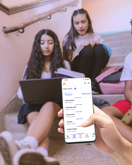 Phone in hand with schedules and kids in bkgnd